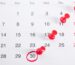 Calendar with tax deadline circled and marked with red pushpins
